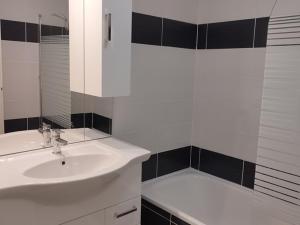 T2 lumineux 6 pers au pied des pistes avec WIFI, balcon, casier à skis, à 5 min des commerces et loisirs - FR-1-262-79 في Forest des Baniols: حمام أبيض مع حوض وحوض استحمام