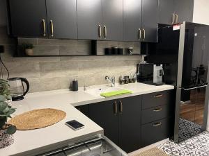 a kitchen with black cabinets and a sink at דירת בוטיק Dnine7 in Haifa