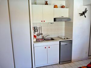 een kleine keuken met witte kasten en een wastafel bij Appartement Marseillan-Plage, 2 pièces, 4 personnes - FR-1-387-50 in Marseillan
