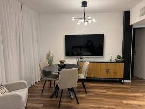 a living room with a dining room table and a tv at דירת בוטיק Dnine7 in Haifa