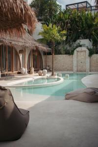 a swimming pool with blue water in a resort at Belajar Bali Boutique Hotel and Retreat in Canggu