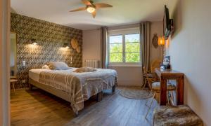 a bedroom with a bed and a ceiling fan at Hotel-Restaurant Le Sorgia in Bellegarde-sur-Valserine