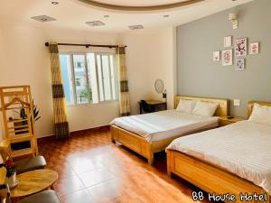 a bedroom with two beds and a window at BB House Hotel Đ&agrave; Lạt in Da Lat