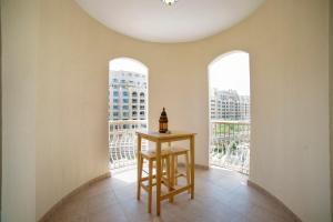 une chambre avec une table et deux fenêtres dans l'établissement Lux Living on Palm Jumeirah With Beach Access & Complimentary Golf, à Dubaï