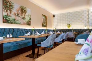 un restaurante con mesas de madera y sillas azules en Hotel Residenz am Rosengarten en Bad Kissingen