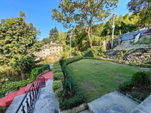 a large yard with a park with a red path at Kiran Lake Paradise Homestay in Bhīm Tāl