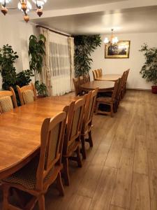 uma sala de jantar com uma grande mesa e cadeiras em Pensiunea Ancuta din Botiza em Botiza