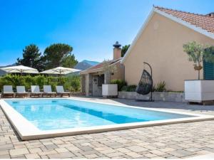 una piscina frente a una casa en Villa Zara with heated Hydromassage-Pool, en Vrgorac