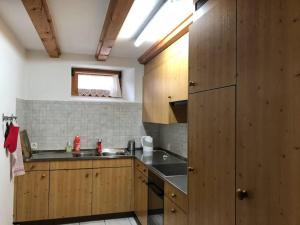 a kitchen with wooden cabinets and a sink at Alte Sennerei in Ober-Says