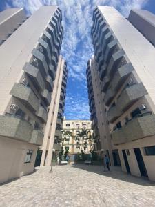 due edifici alti con un cielo blu sullo sfondo di Apto a 2 min a Pé da Praia - Edificio Monte Carmel a Guarujá