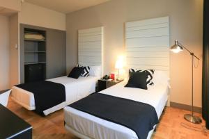 una camera d'albergo con due letti e una lampada di Hotel Leyre a Pamplona