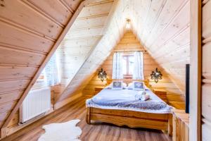 una camera da letto in una baita di tronchi con letto di Domek u Wawrytki a Zakopane