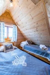 una camera con 2 letti in una baita di tronchi di Domek u Wawrytki a Zakopane