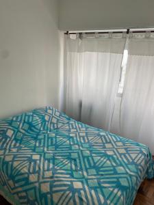 1 cama en un dormitorio con cortinas blancas en Catamarca 9 Julio en Mar del Plata