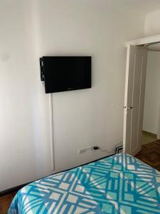 1 dormitorio con TV de pantalla plana en la pared en Catamarca 9 Julio en Mar del Plata