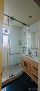 y baño con lavabo y ducha acristalada. en Top floor sunny bedroom near Fudan, en Shanghái
