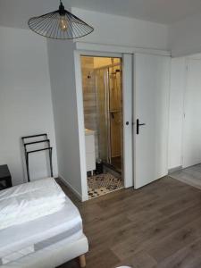 een slaapkamer met een bed en een deur naar een badkamer bij Grain de café Barneville Plage in Barneville-Carteret