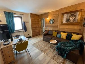 un soggiorno con divano e tavolo di Apartment Gran Baita Sauze d'Oulx a Sauze d'Oulx