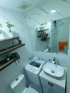 uma casa de banho branca com um WC e um lavatório em Cozy studio unit at Sun Residences em Manila