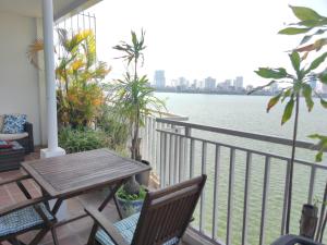 a balcony with a table and chairs and the water at Davidduc's Apartment Quang Khanh in Hanoi