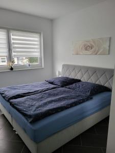 a bedroom with a bed with a blue comforter at Gästewohnung 6 in Oschersleben