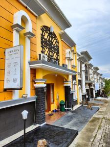 ein gelbes Gebäude mit einem Schild davor in der Unterkunft Adiputra Guesthouse Tata Bumi in Ngabean