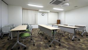 um quarto vazio com secretárias e cadeiras e um relógio em Toyoko Inn Iseshi Eki em Ise