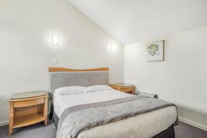 a bedroom with a bed and two night stands at Capital Lodge Motor Inn in Wellington