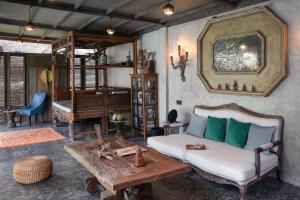 Sala de estar con cama, mesa y piano en Tabanan Villas en Tabanan