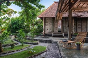 a garden in front of a house with a chair at Tabanan Villas in Tabanan