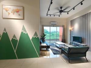 ein Wohnzimmer mit einer grünen Wand mit bemalten Bergen in der Unterkunft Pavilionvillie M1T11 by irainbow in Simpang Pulai