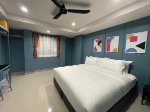 a bedroom with a large white bed with blue walls at Sari Boutique hotel in Patong Beach