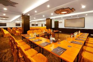 a conference room with tables and chairs and a projection screen at Hotel Sarowar in Pokhara