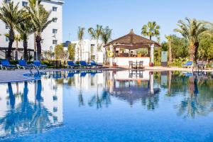 a swimming pool with chairs and a gazebo at Relax Hotel Airport Nouasseur in Nouaseur