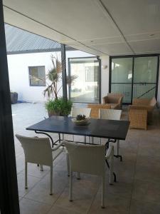 czarny stół i krzesła w pokoju z oknami w obiekcie Mountain view house 9 Diemersfontein w mieście Wellington