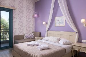 a bedroom with purple walls and a bed with towels on it at Villa Anthelion in Limenaria