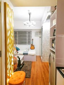 um quarto com uma cama com uma guitarra em Cozy studio unit at Sun Residences em Manila