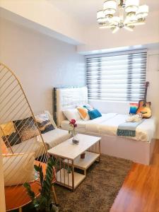 uma sala de estar com uma cama e um sofá em Cozy studio unit at Sun Residences em Manila