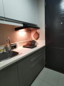 a kitchen with a sink and a counter top at Baseline Premier - Studio with mountain view in Cebu City