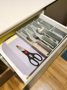 a drawer with scissors and other utensils in it at Romantic Log Cabin - walk to KL Tower, KLCC, Bukit Bintang in Kuala Lumpur