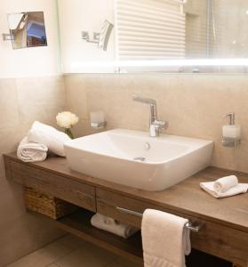 uma casa de banho com um lavatório branco e um espelho. em Rottach Apartments - Ferienwohnungen am Tegernsee em Rottach-Egern