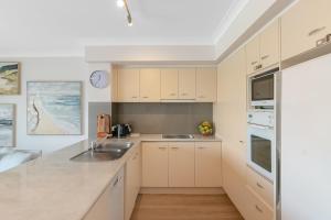 Η κουζίνα ή μικρή κουζίνα στο Sunrise Cove- 2BR Waterfront Apartment by uHoliday +5 φωτογραφίες