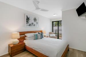 a bedroom with a bed and a flat screen tv at Sunrise Cove- 2BR Waterfront Apartment by uHoliday in Kingscliff