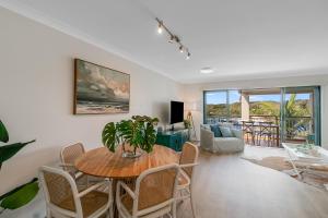 a living room with a table and chairs at Sunrise Cove- 2BR Waterfront Apartment by uHoliday in Kingscliff