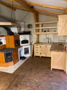 a large kitchen with white appliances and wooden cabinets at Dom Wiktor 