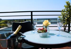 a table with a bottle of wine and glasses on a balcony at The Max Hotel Sandton in Johannesburg +79 photos
