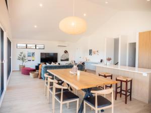 荷伯特的住宿－Luxurious Waterfront home in the North of Hobart，用餐室以及带木桌和椅子的客厅。