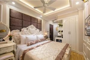 a bedroom with a large white bed and a ceiling at Royal Holiday Hanoi Hotel in Hanoi