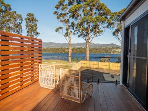 eine Terrasse mit Stühlen und Blick auf das Wasser in der Unterkunft Luxurious Waterfront home in the North of Hobart in Hobart