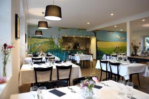 un restaurant avec tables et chaises et nappes blanches dans l'établissement Auberge de La Sauge, à Cudrefin